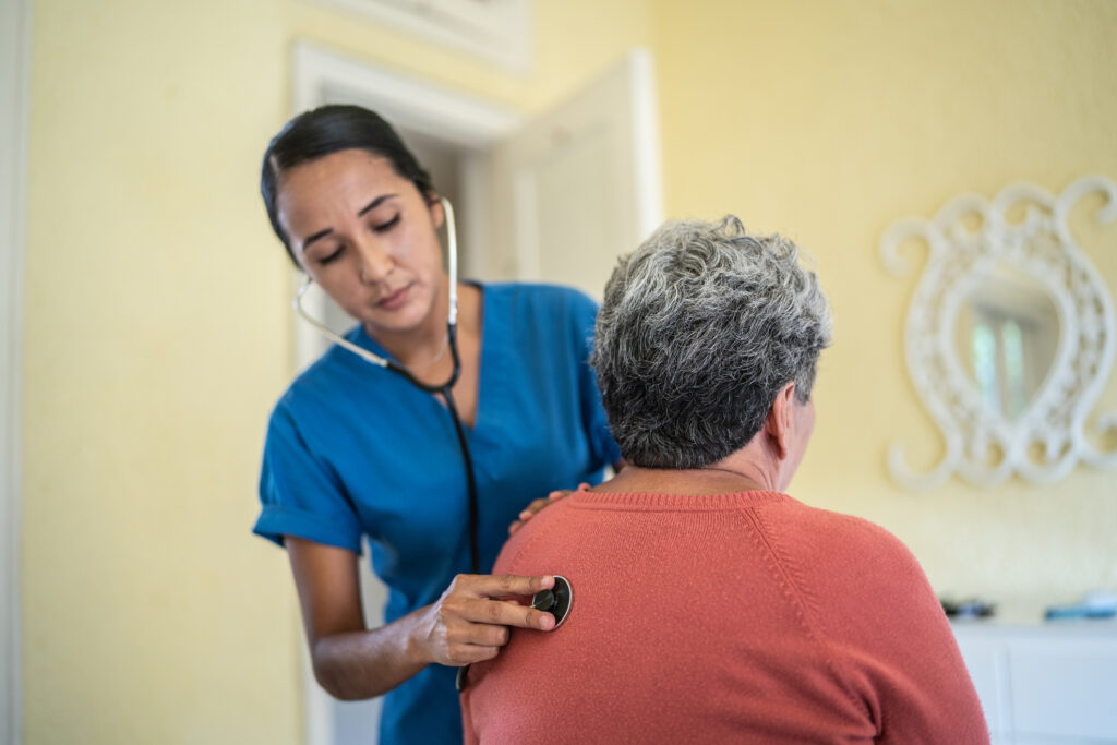 Nurse examining womans lungs using stethoscope